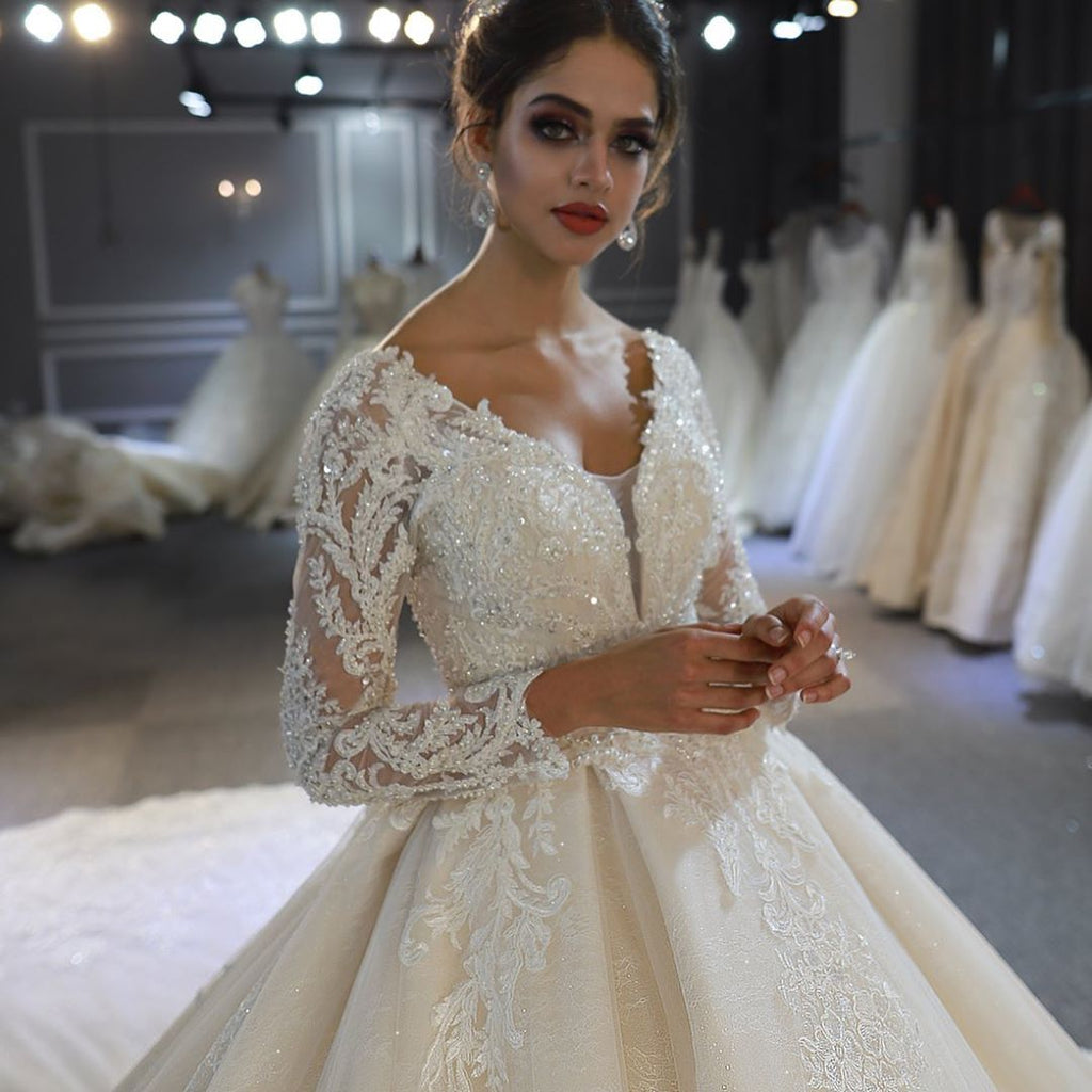Vestido de novia largo de corte A, escote corazón, espalda descubierta, apliques de encaje y lentejuelas, con mangas.