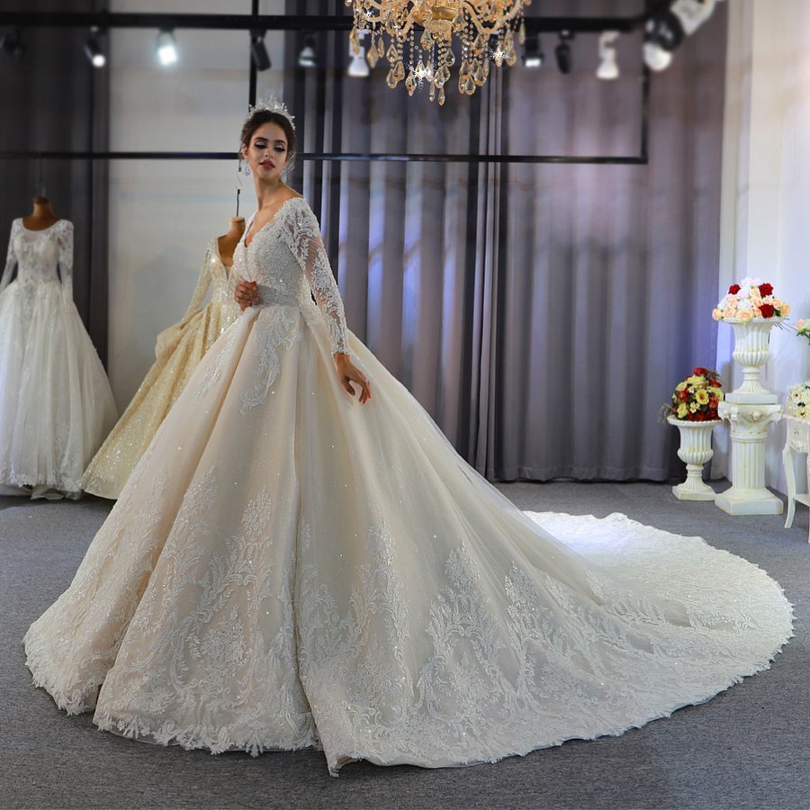 Vestido de novia largo de corte A, escote corazón, espalda descubierta, apliques de encaje y lentejuelas, con mangas.