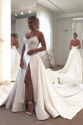 Robe de mariée longue trapèze en satin, dos nu et décolleté cœur, avec fente.