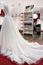 Vestido de novia largo de corte A, sin mangas, con volantes, joyas y aplicaciones de encaje.