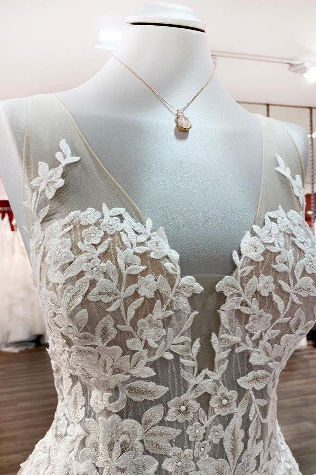 Vestido de novia largo de corte A, sin mangas, con volantes, joyas y aplicaciones de encaje.