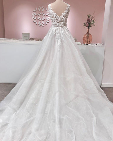 Vestido de novia largo de corte A con escote en V, apliques de encaje, espalda descubierta y volantes de tul.