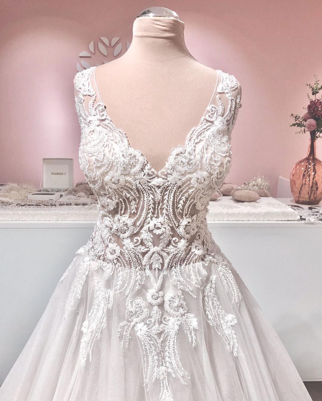 Robe de mariée longue trapèze en tulle à volants, dos nu, col en V et applications de dentelle, ornée de décolletés en V et d'appliques.