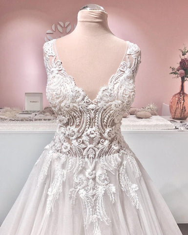 Vestido de novia largo de corte A con escote en V, apliques de encaje, espalda descubierta y volantes de tul.