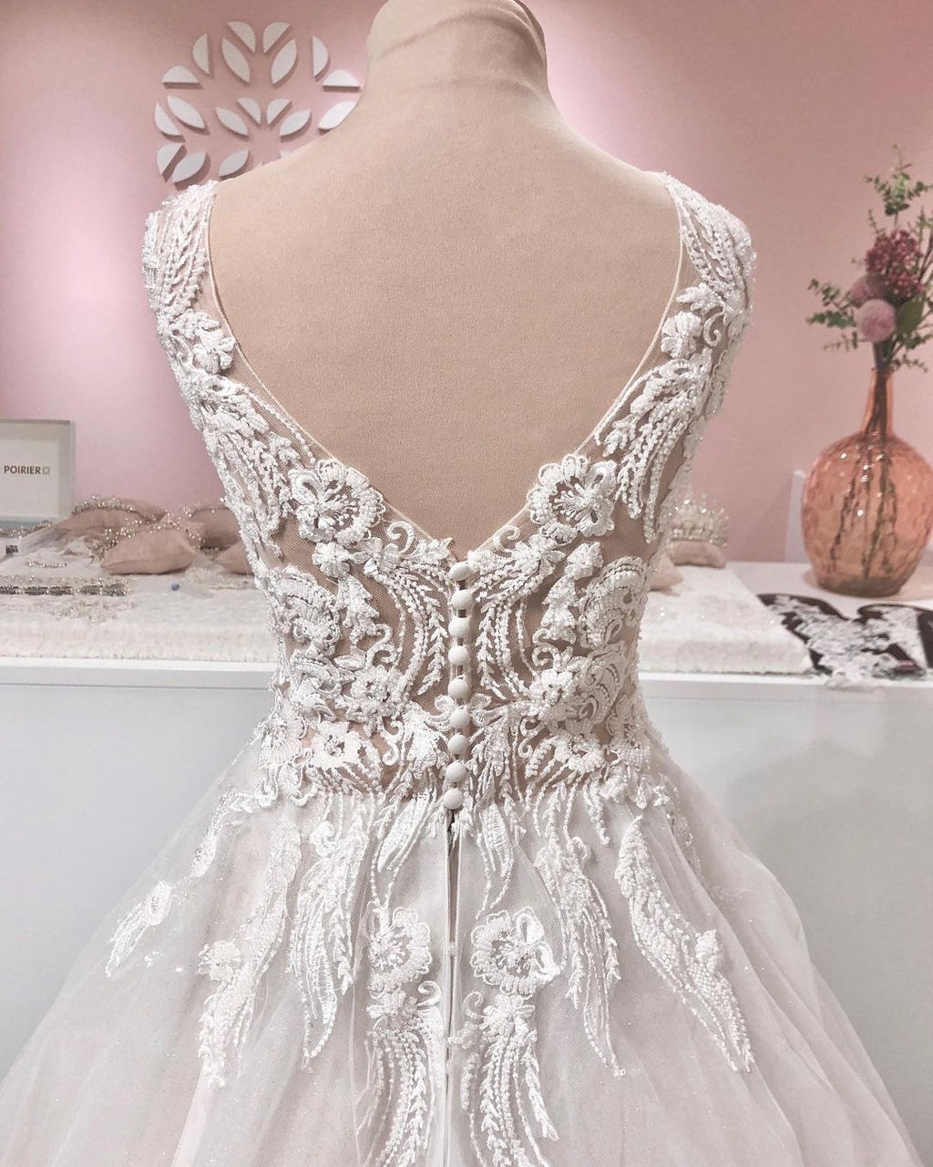 Robe de mariée longue trapèze en tulle à volants, dos nu, col en V et applications de dentelle, ornée de décolletés en V et d'appliques.