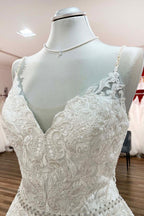 Vestido de novia largo de corte A, escote en V, tirantes finos, espalda descubierta y encaje.