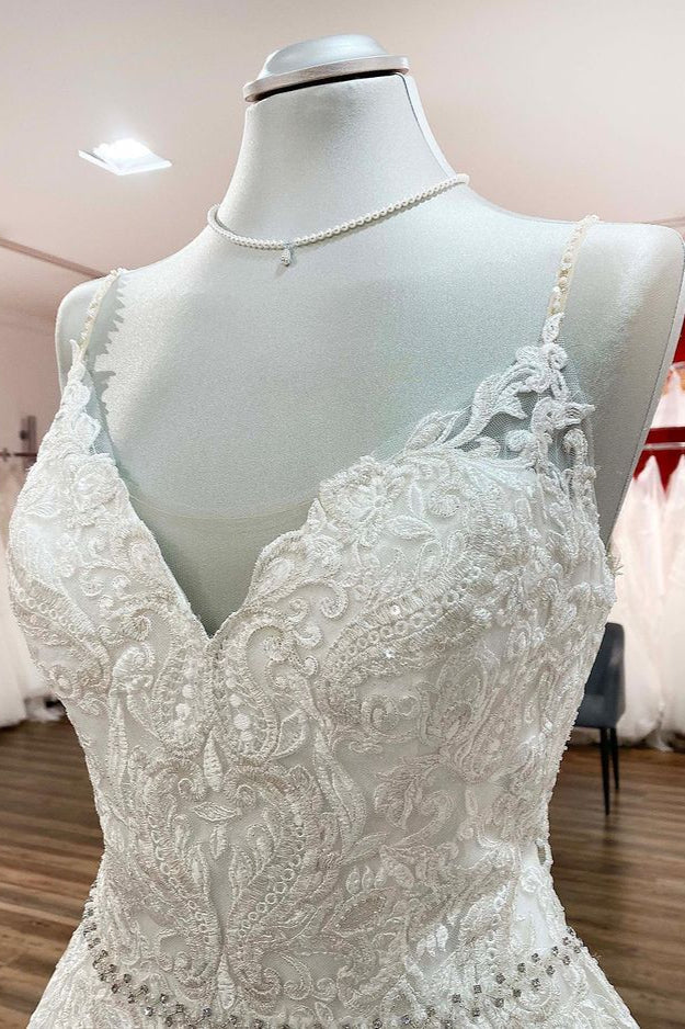 Vestido de novia largo de corte A, escote en V, tirantes finos, espalda descubierta y encaje.