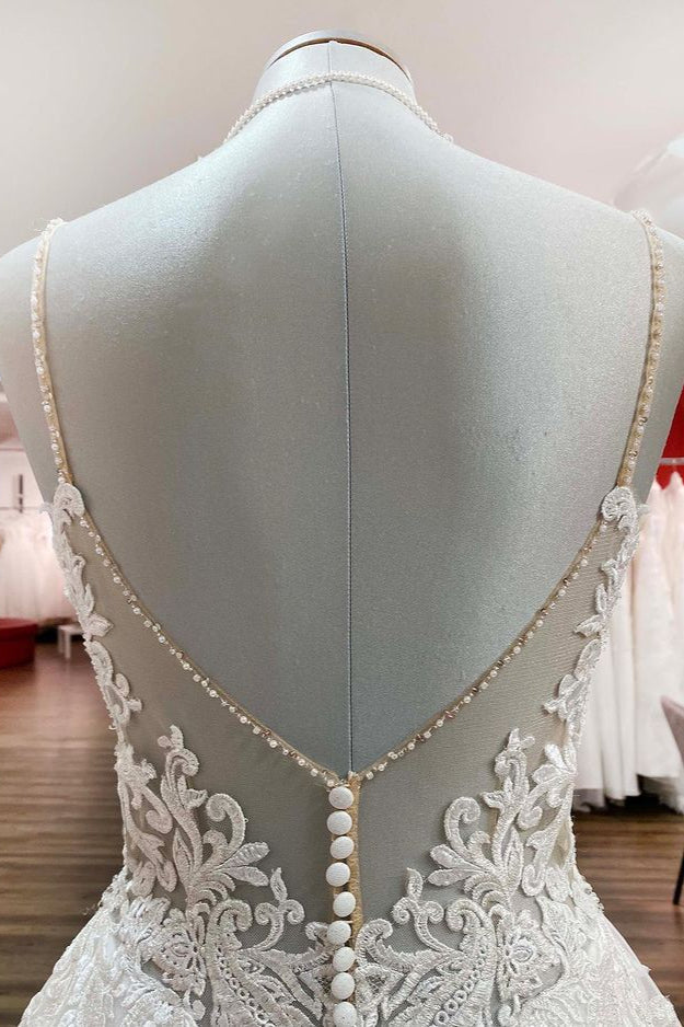 Vestido de novia largo de corte A, escote en V, tirantes finos, espalda descubierta y encaje.