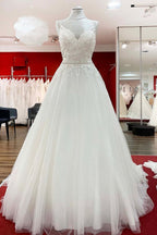 Vestido de novia largo de corte A, escote en V, tirantes finos, espalda descubierta y encaje.