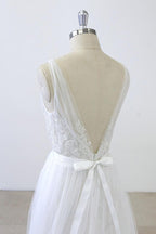 Robe de mariée longue en tulle dos nu, coupe trapèze, décolleté en V, bustier cœur, volants et appliques