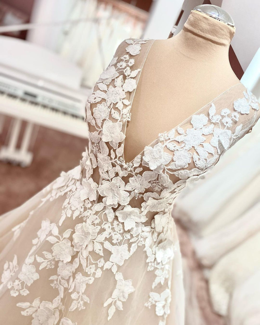 Robe de mariée longue trapèze en tulle et dentelle à bretelles larges et dos nu, ornée d'appliques en dentelle et en tulle, col en V et décolleté en V.