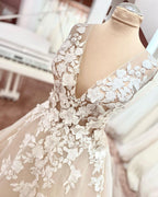 Robe de mariée longue trapèze en tulle et dentelle à bretelles larges et dos nu, ornée d'appliques en dentelle et en tulle, col en V et décolleté en V.