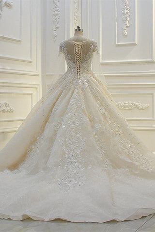 Vestido de novia largo de baile con apliques de encaje y escote barco, con mangas y pedrería.