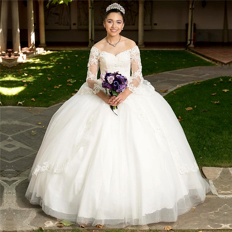 Robe de bal longue blanche en tulle à épaules dénudées et manches longues, idéale pour une quinceañera.