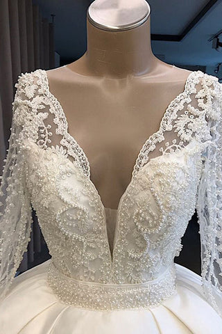 Vestido de novia largo de corte princesa, de satén, con escote en V y mangas.