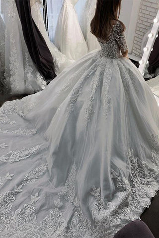 Vestido de novia largo de corte princesa con escote corazón, apliques de encaje y tul, con mangas.