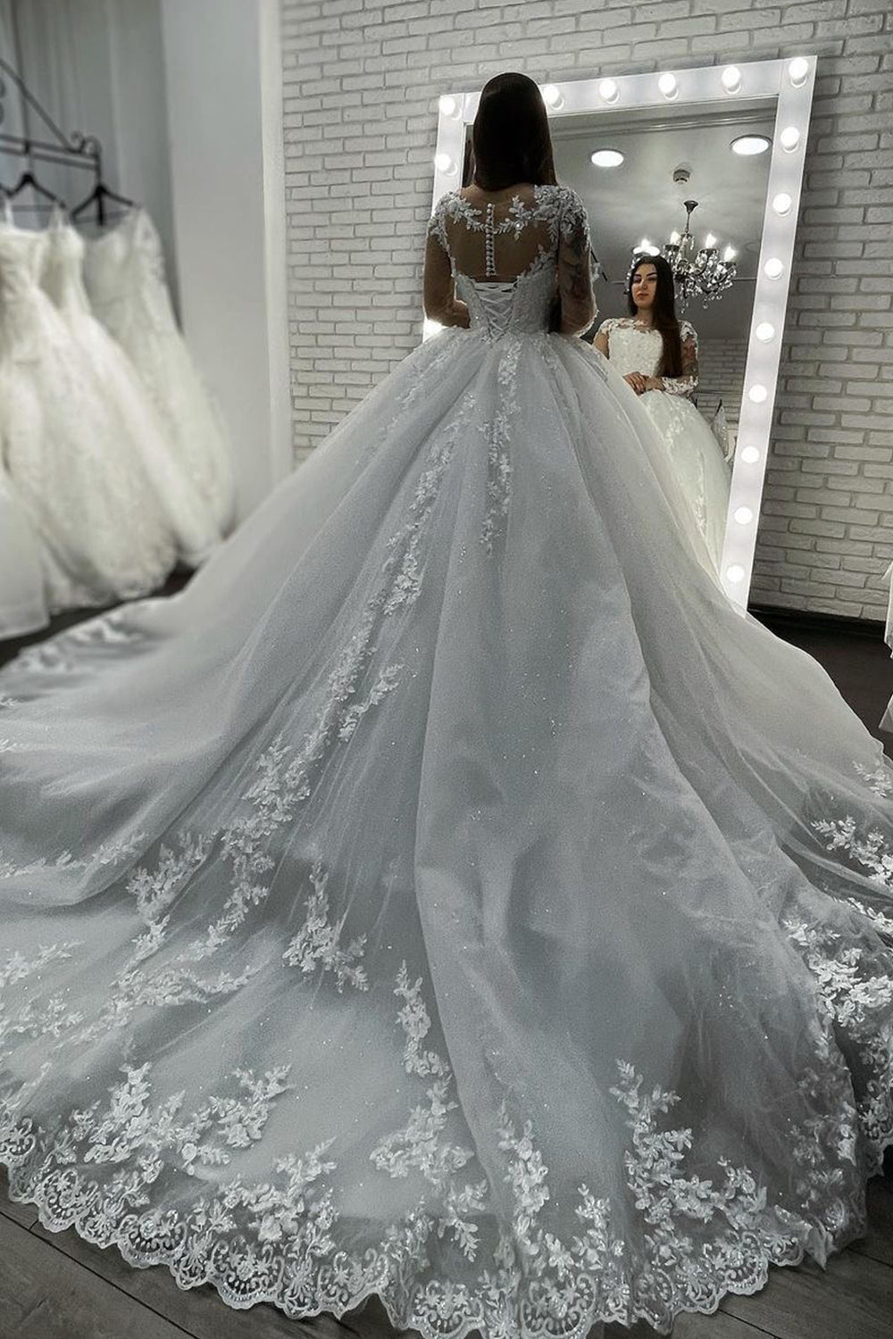 Vestido de novia largo de corte princesa con escote corazón, apliques de encaje y tul, con mangas.