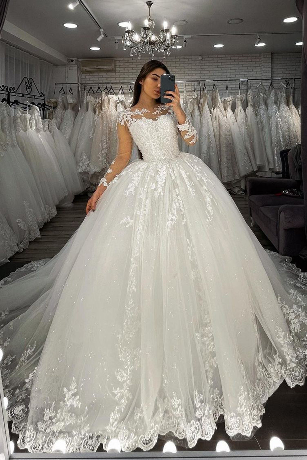 Vestido de novia largo de corte princesa con escote corazón, apliques de encaje y tul, con mangas.
