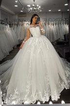 Vestido de novia largo de corte princesa con escote corazón, apliques de encaje y tul, con mangas.