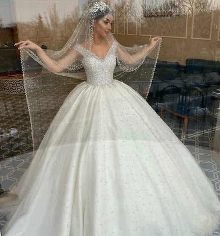 Vestido de novia largo de corte princesa, escote corazón, espalda descubierta, con perlas, volantes y tul.