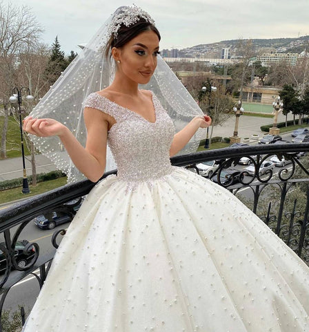 Vestido de novia largo de corte princesa, escote corazón, espalda descubierta, con perlas, volantes y tul.
