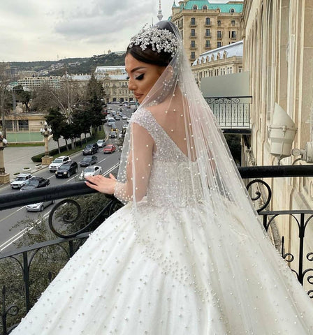 Vestido de novia largo de corte princesa, escote corazón, espalda descubierta, con perlas, volantes y tul.