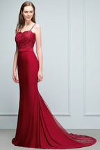 Robe de bal longue bordeaux sirène à bretelles spaghetti et décolleté cœur orné d'appliques et de perles.