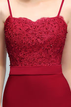 Robe de bal longue bordeaux sirène à bretelles spaghetti et décolleté cœur orné d'appliques et de perles.