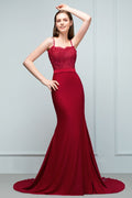 Robe de bal longue bordeaux sirène à bretelles spaghetti et décolleté cœur orné d'appliques et de perles.