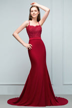Robe de bal longue bordeaux sirène à bretelles spaghetti et décolleté cœur orné d'appliques et de perles.