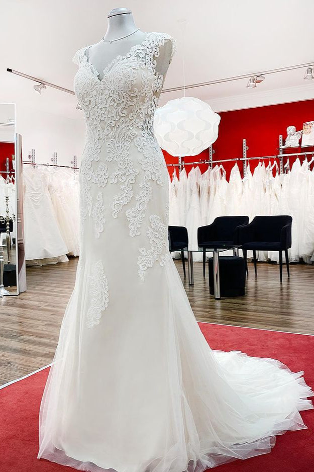 Robe de mariée sirène longue en dentelle, décolleté cœur et dos nu, ornée d'appliqués de dentelle.