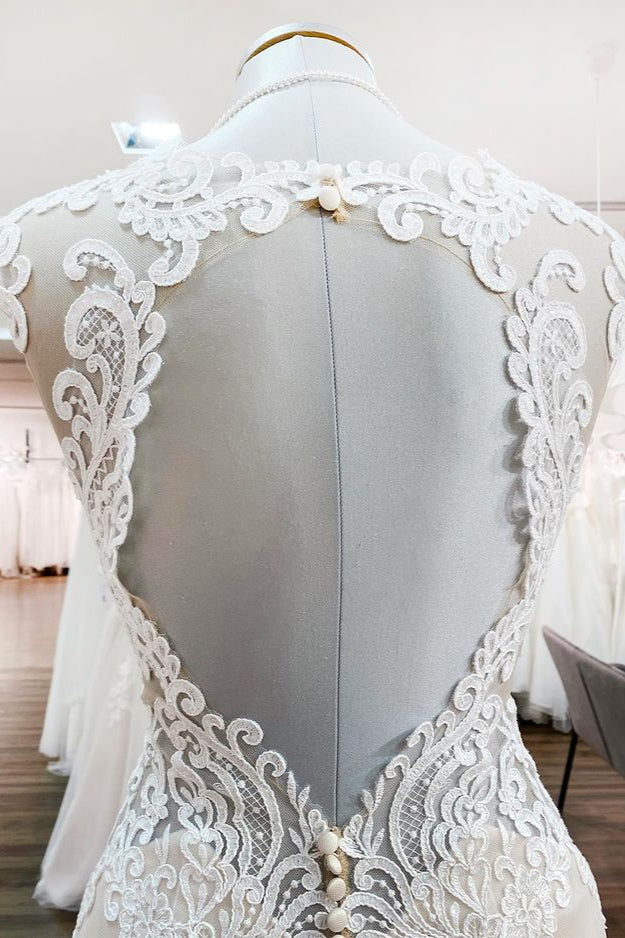 Robe de mariée sirène longue en dentelle, décolleté cœur et dos nu, ornée d'appliqués de dentelle.