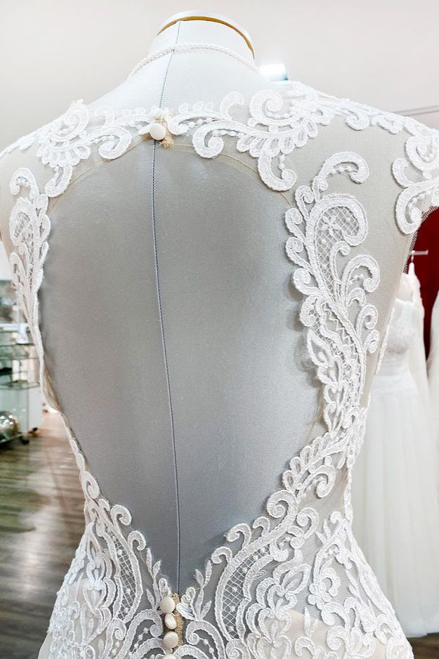 Robe de mariée sirène longue en dentelle, décolleté cœur et dos nu, ornée d'appliqués de dentelle.