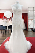 Robe de mariée sirène longue en dentelle, décolleté cœur et dos nu, ornée d'appliqués de dentelle.
