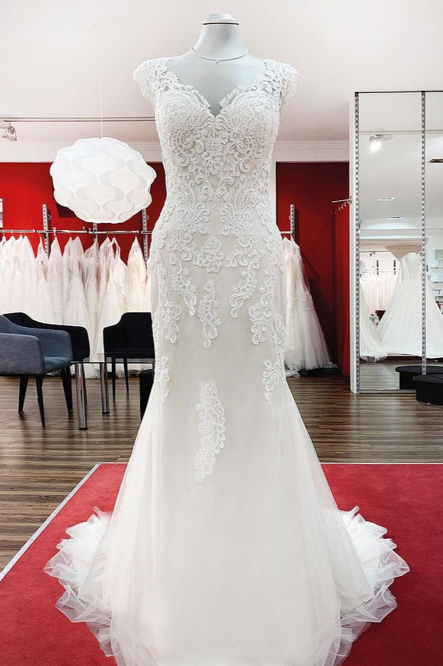 Robe de mariée sirène longue en dentelle, décolleté cœur et dos nu, ornée d'appliqués de dentelle.