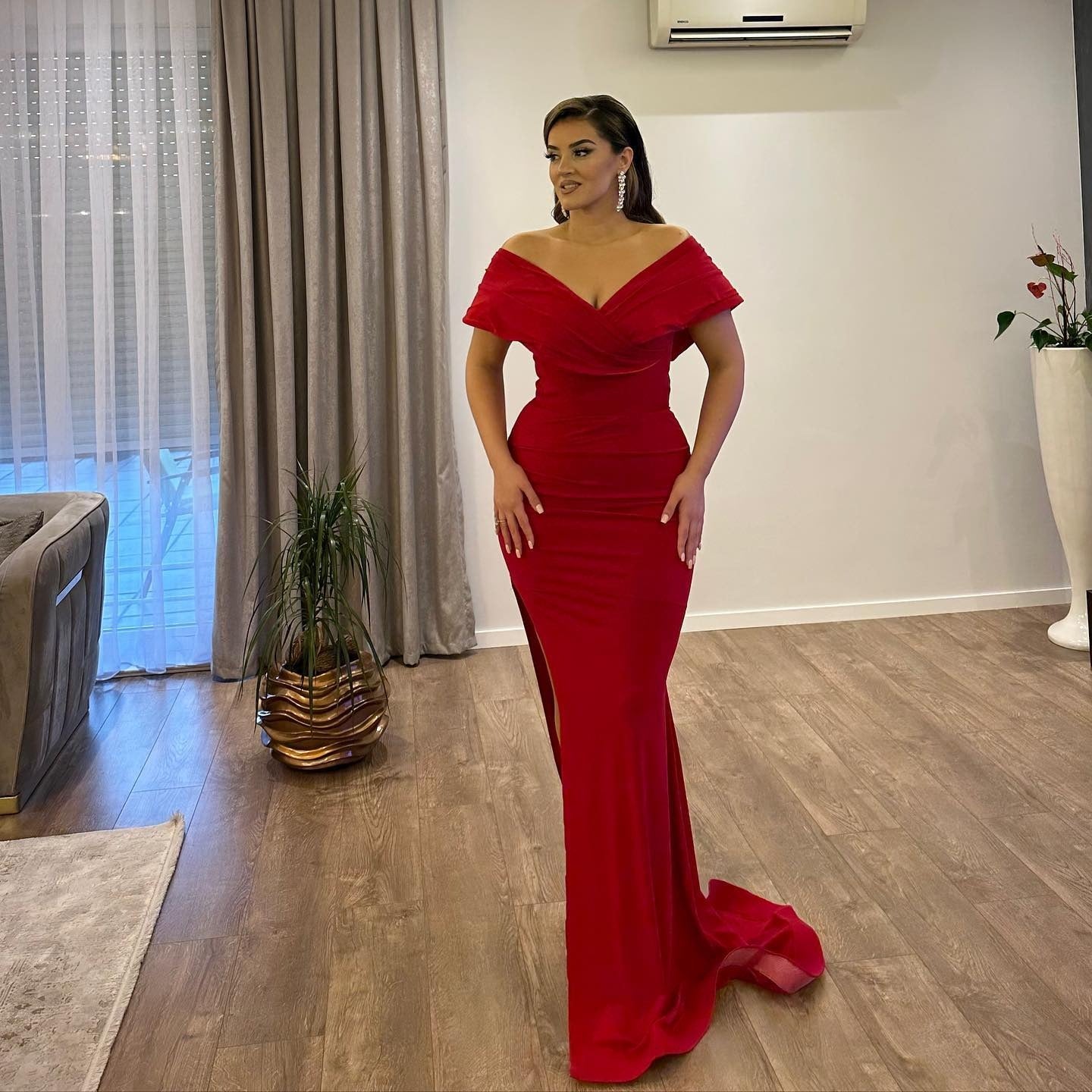 Vestido largo de sirena rojo satinado con hombros descubiertos y abertura para baile de graduación.