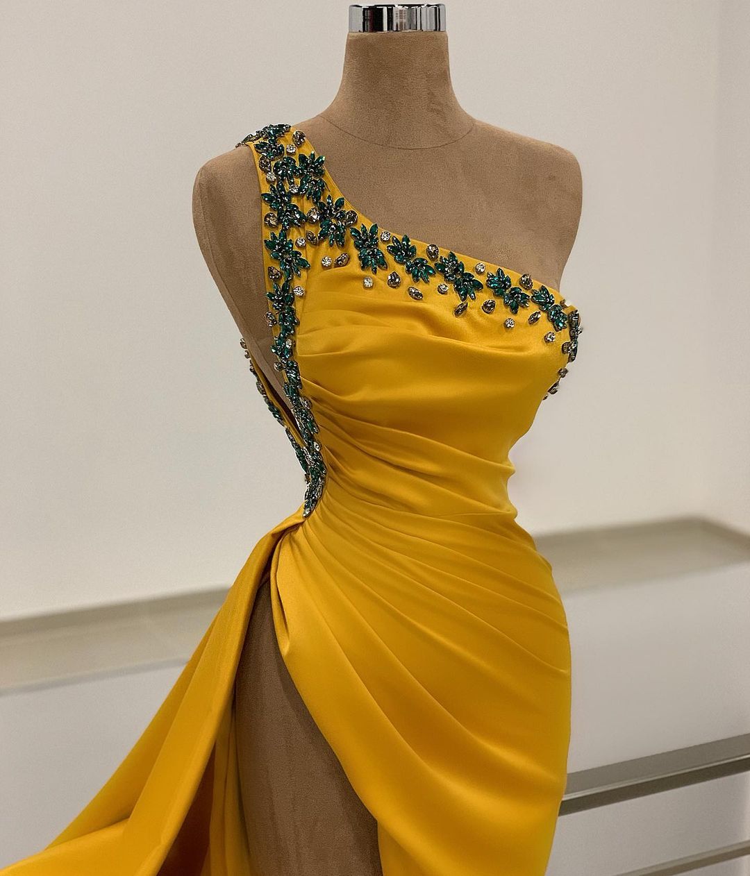 Robe de bal longue sirène asymétrique dos nu ornée de perles et fendue.