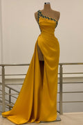 Robe de bal longue sirène asymétrique dos nu ornée de perles et fendue.
