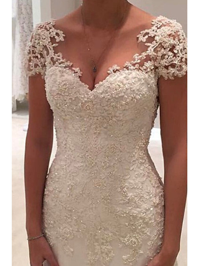 Vestidos de novia largos de sirena con escote en V, tul, encaje y espalda descubierta con mangas cortas.