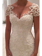 Vestidos de novia largos de sirena con escote en V, tul, encaje y espalda descubierta con mangas cortas.