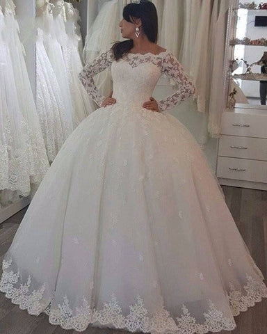 Vestido de novia princesa de manga larga con hombros descubiertos y apliques de encaje.