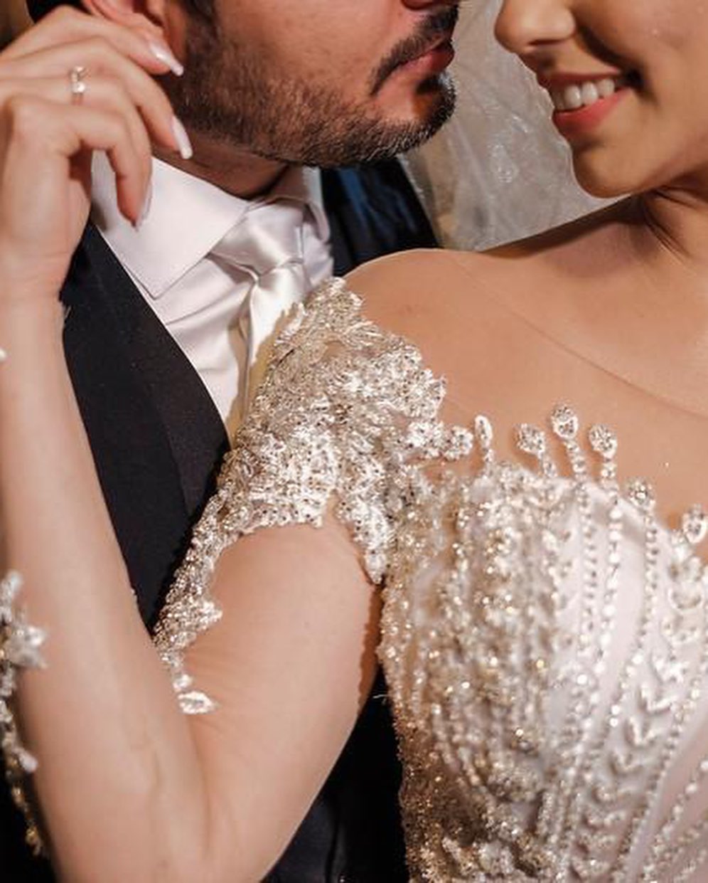 Vestido de novia de tul corte sirena, manga larga, hombros descubiertos, con apliques de encaje y mangas largas.