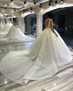 Vestido de novia largo de corte princesa con escote corazón, espalda descubierta, apliques de encaje y lentejuelas