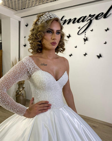 Vestido de novia largo de satén con escote corazón, volantes y mangas, estilo princesa.