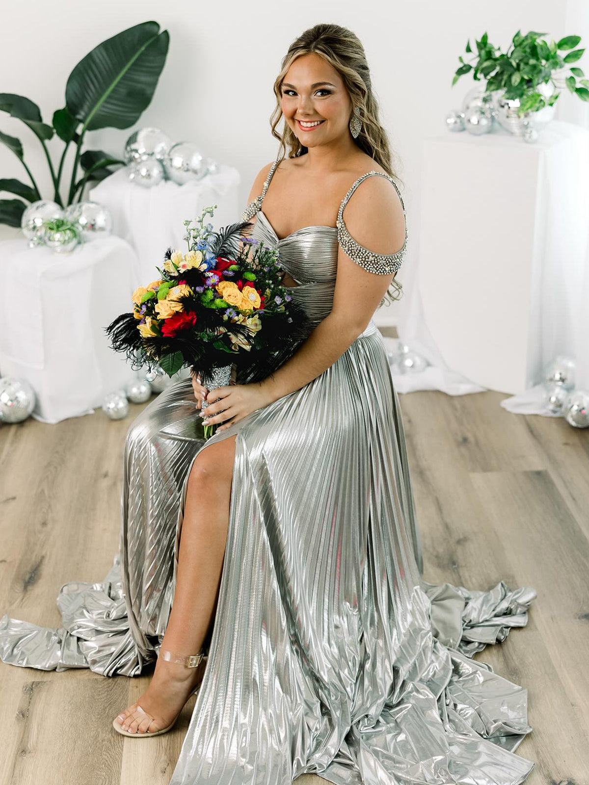 Lulu | Vestido largo de gala dorado con hombros descubiertos, corte en A y pliegues metálicos 