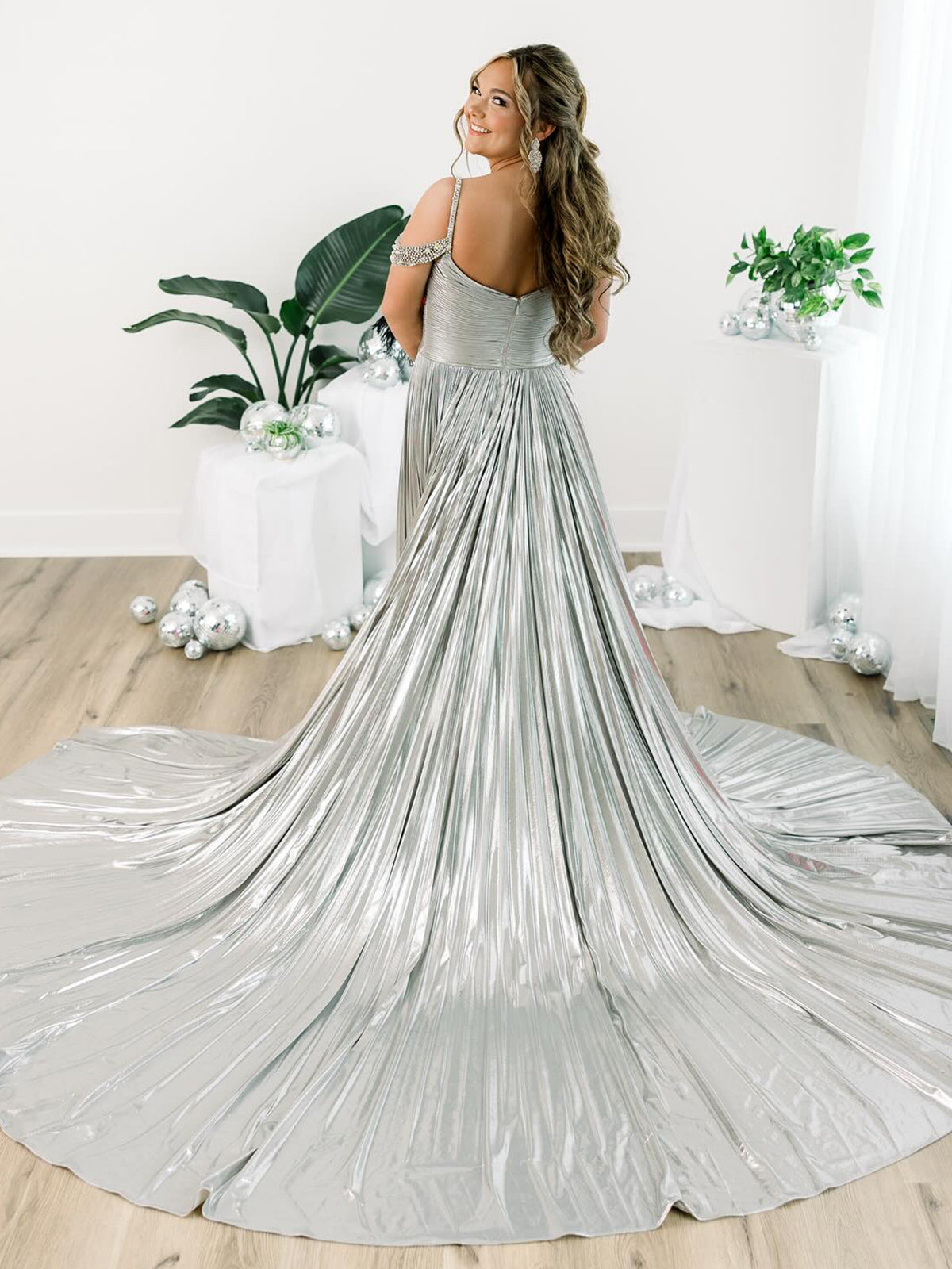Lulu | Vestido largo de gala dorado con hombros descubiertos, corte en A y pliegues metálicos 
