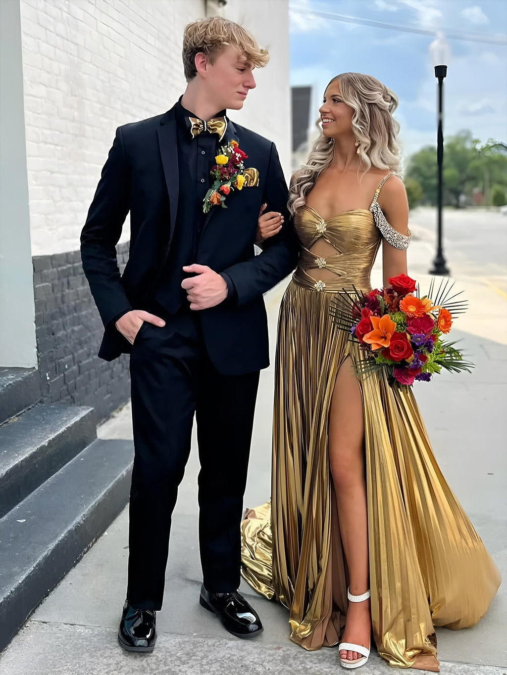 Lulu | Vestido largo de gala dorado con hombros descubiertos, corte en A y pliegues metálicos 