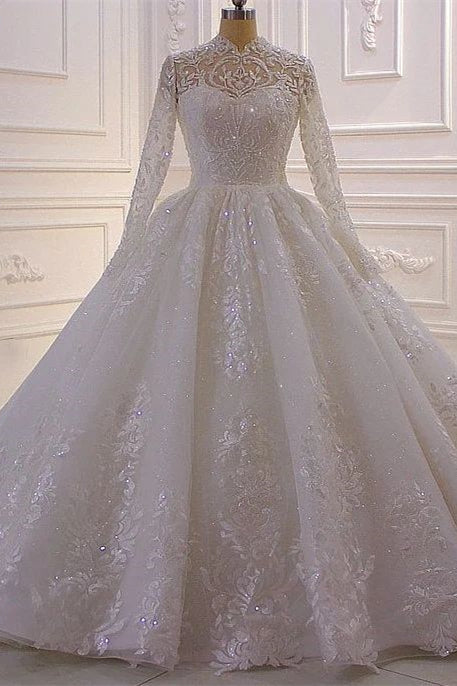 Lujoso vestido de novia de encaje con lentejuelas, corte línea A y cuello alto, con mangas largas.
