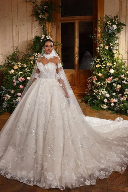 Robe de mariée longue ivoire luxueuse, coupe princesse sans manches, ornée de paillettes et de dentelle.
