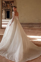 Robe de mariée longue ivoire luxueuse, coupe trapèze, col carré, ornée de dentelle et de perles, manches longues